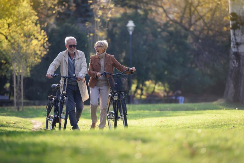 Twee mensen lopen met de fiets aan de hand in de natuur